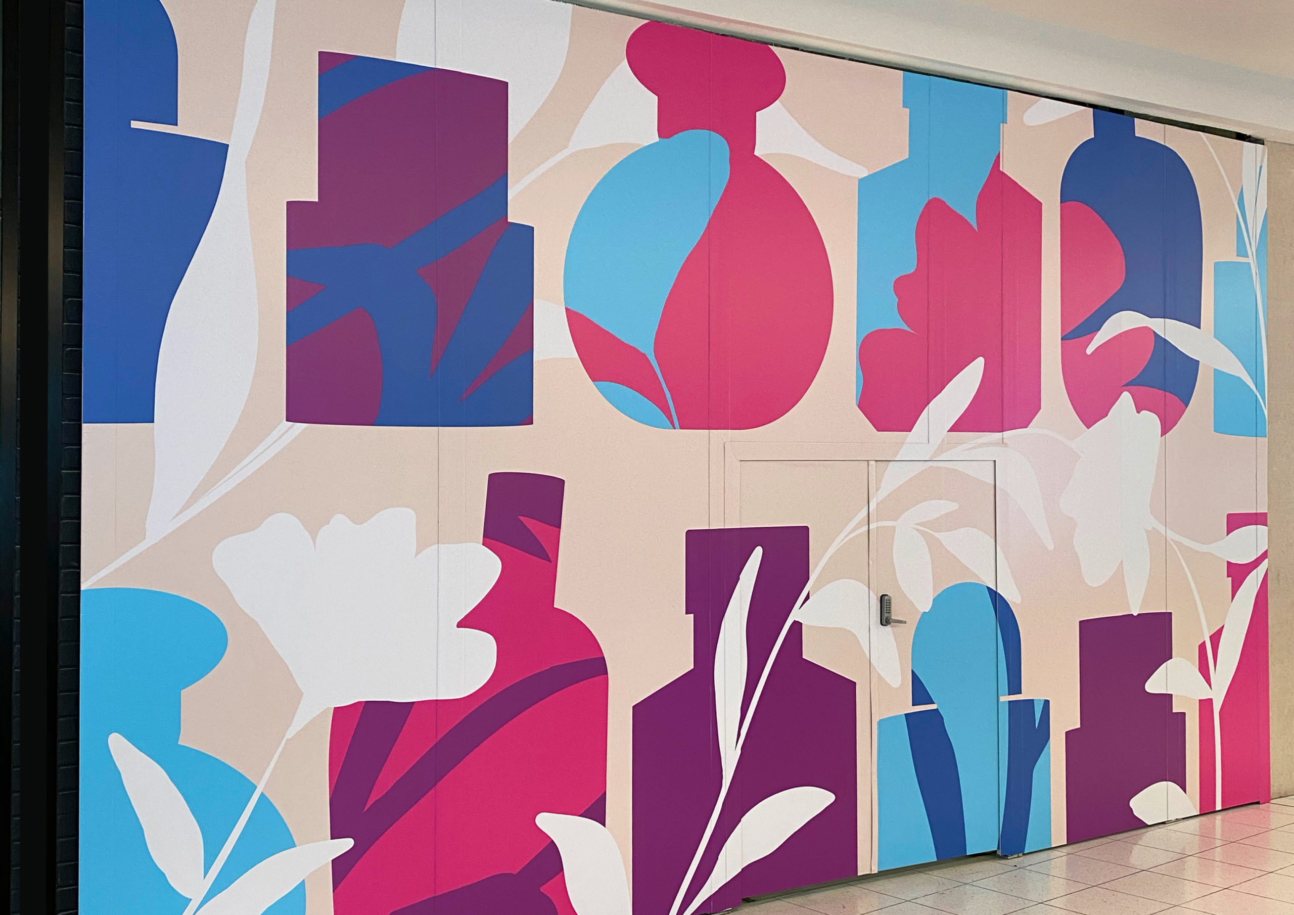 Large scale retail graphics at Sylvia Park Level 1 Launch featuring illustrated oversized perfume bottles overlayed with pink, purple and blue blooms