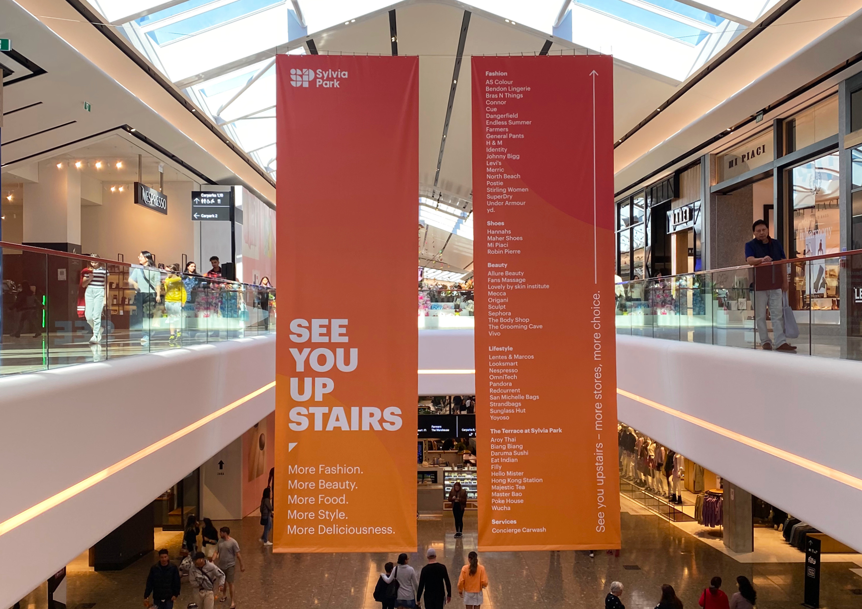 Large scale hanging Banners designed to capture shoppers' attention to drive foot traffic to new Level 1 retail at Sylvia Park , New Zealand's largest shopping mall