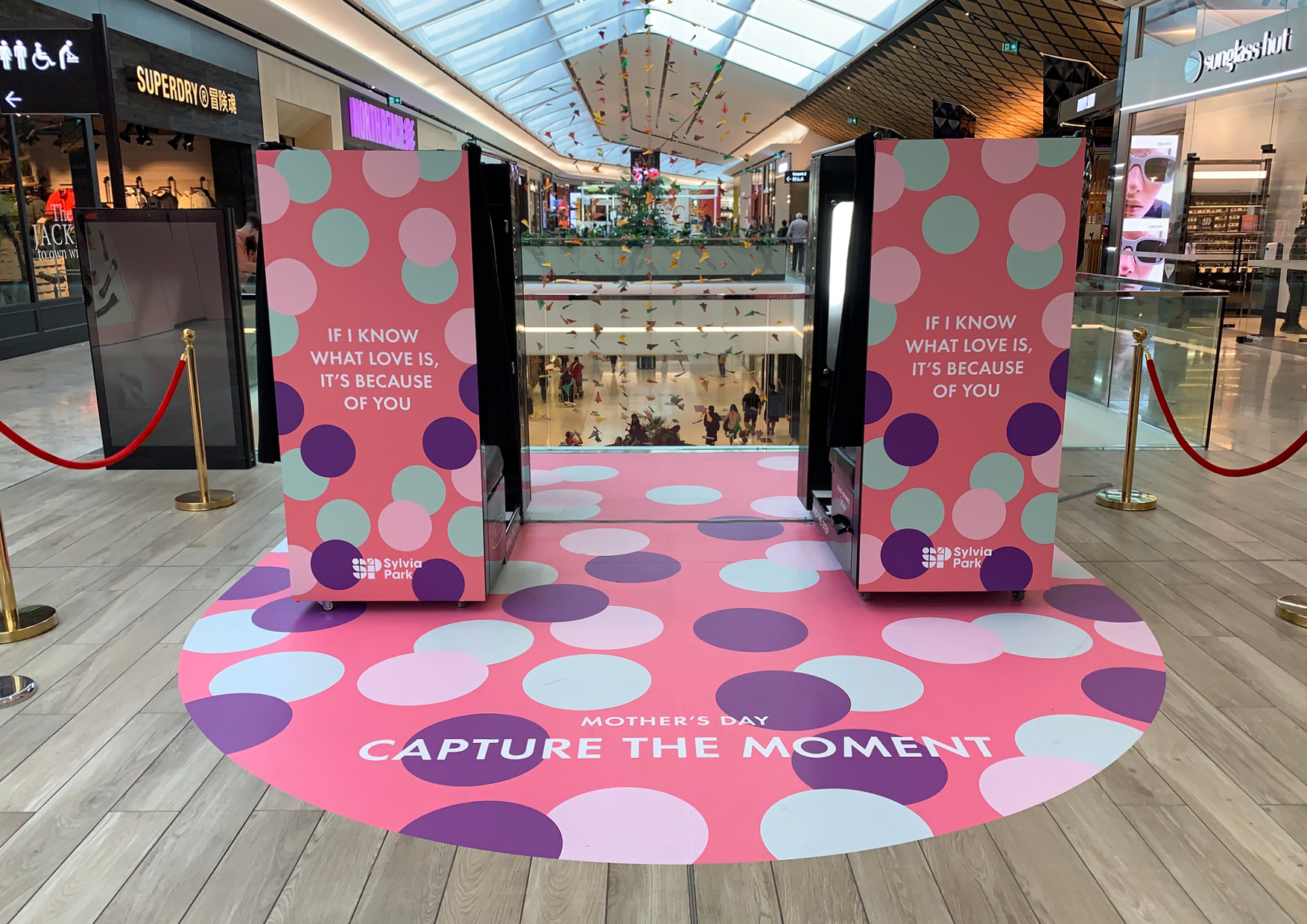 Two playfully coloured photo booths and curving floor decal 'Capture the moment' at Sylvia Park Shopping Centre retail activation